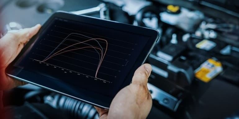 A Person Is Holding A Tablet In Front Of A Car Engine — North Queensland Diesel Tune In Kirwan, QLD