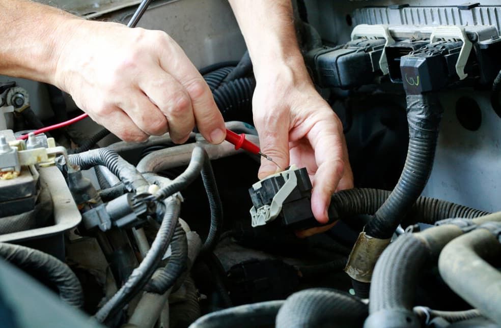 A Person Is Working On A Car Engine With A Pair Of Pliers — North Queensland Diesel Tune In Kirwan, QLD