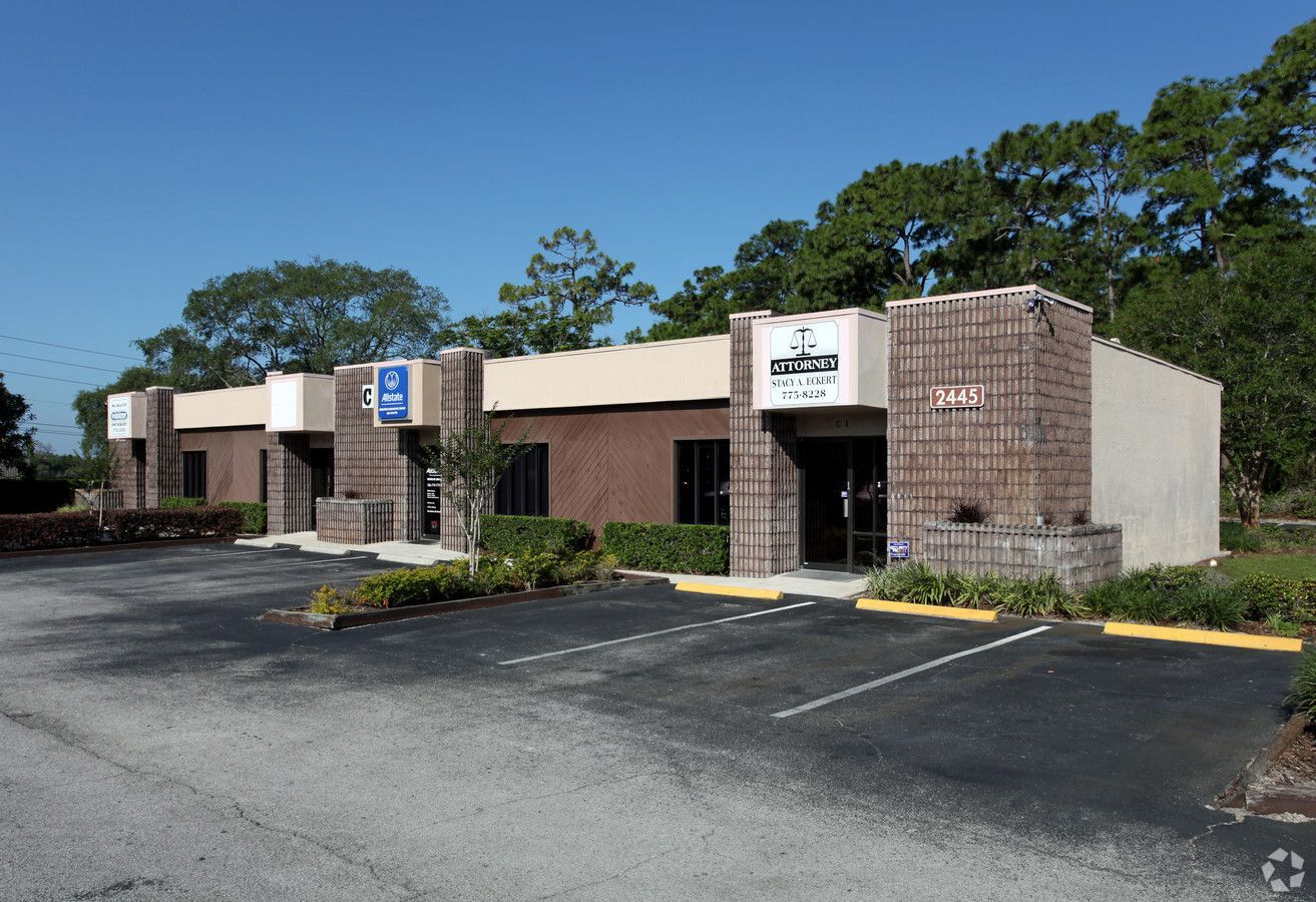 A row of buildings with a parking lot in front of them