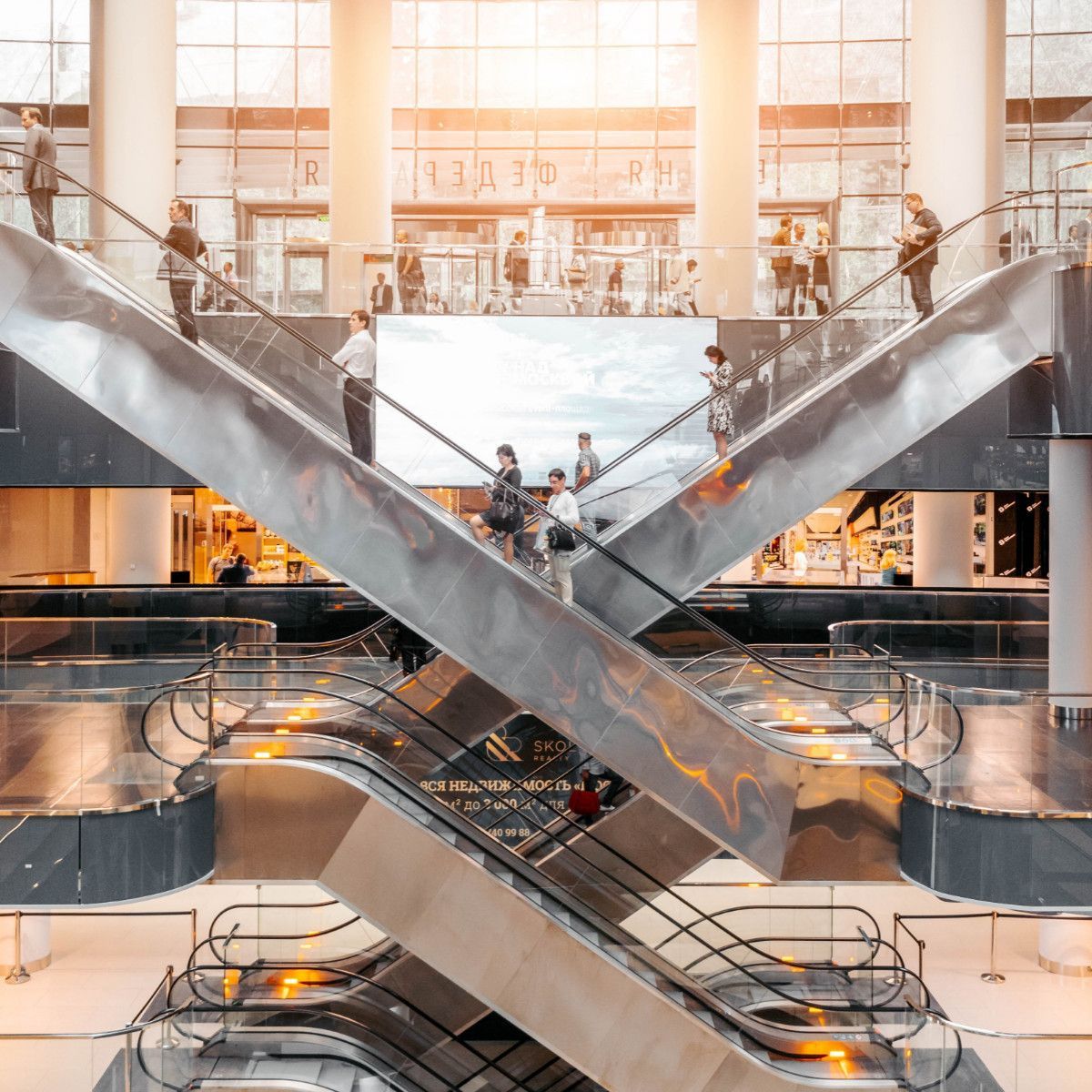 A group of people are riding escalators in a large building.