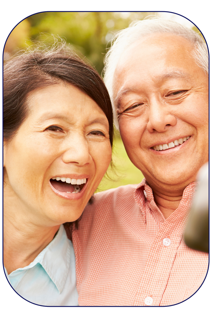 An older couple smiles and laughs while posing for a selfie photo