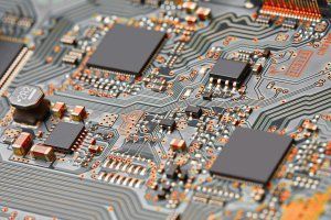 Close-up of a circuit board with microchips, solder joints, and intricate copper traces