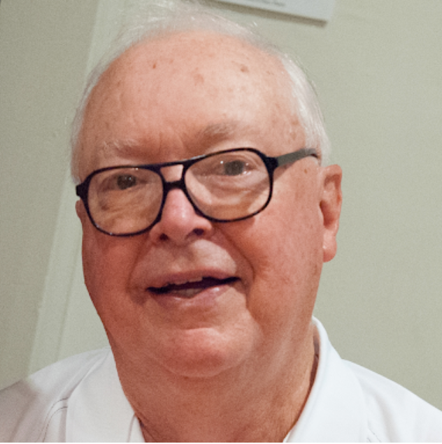 A close up of a man wearing glasses and a white shirt