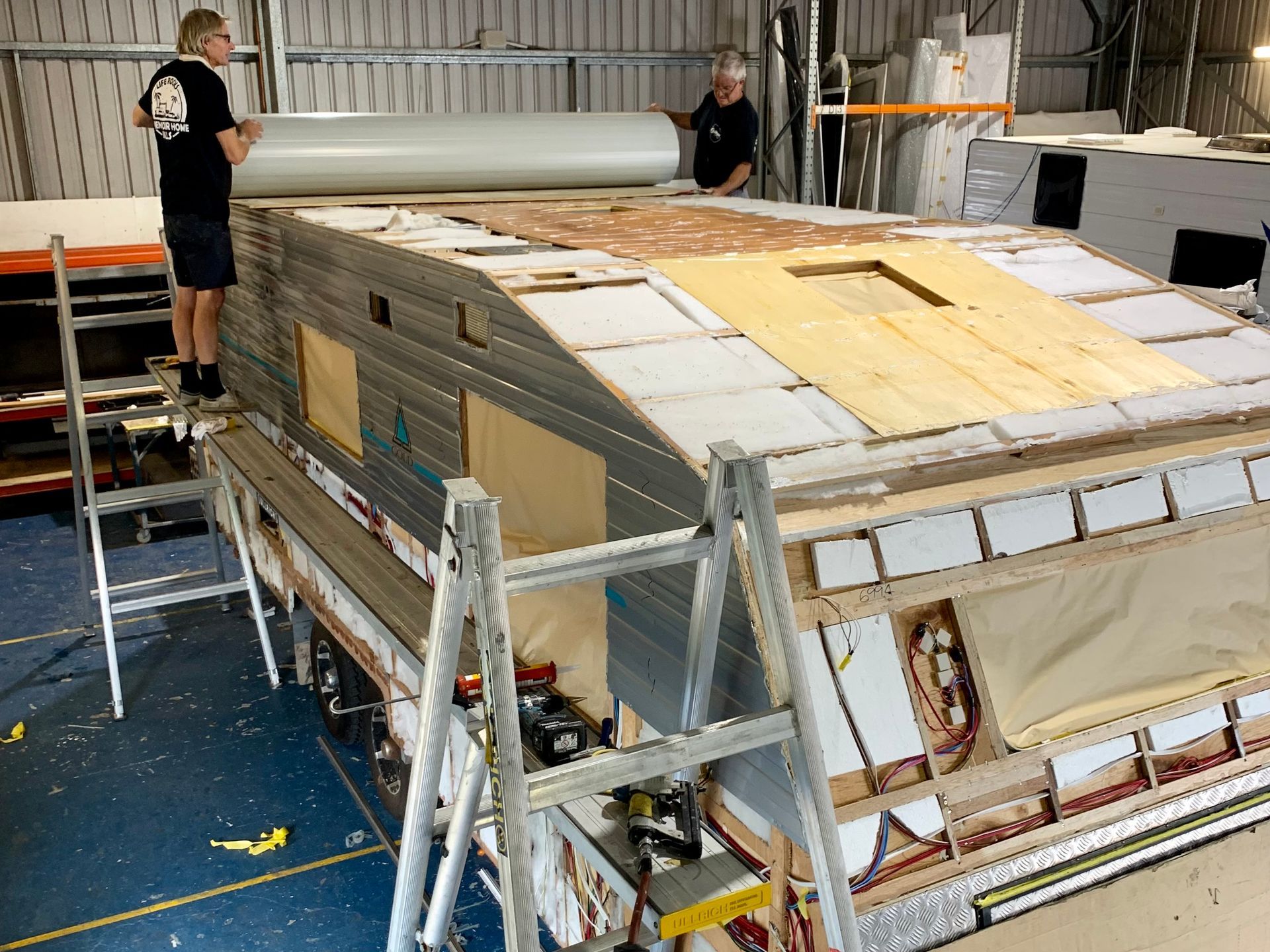 Two men are working on a roof of a building