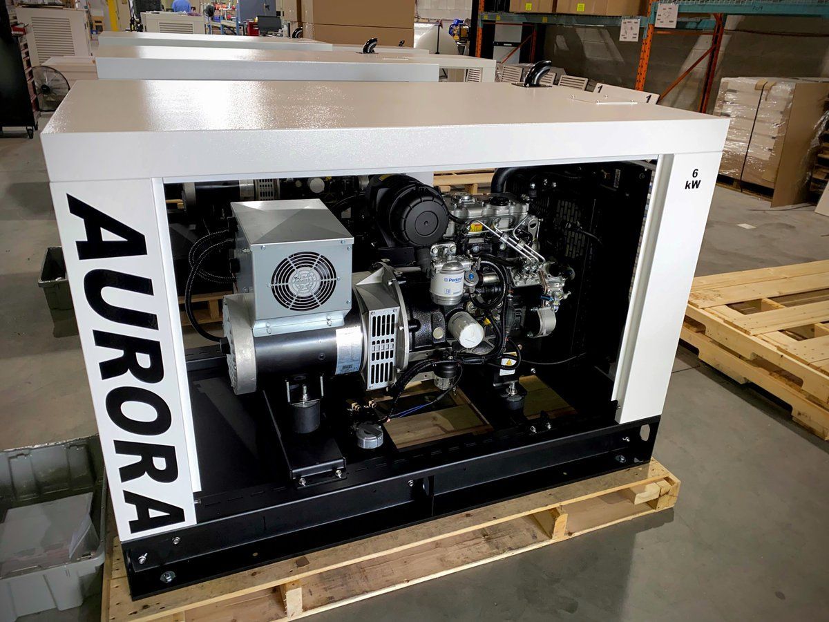 A generator is sitting on a wooden pallet in a warehouse.