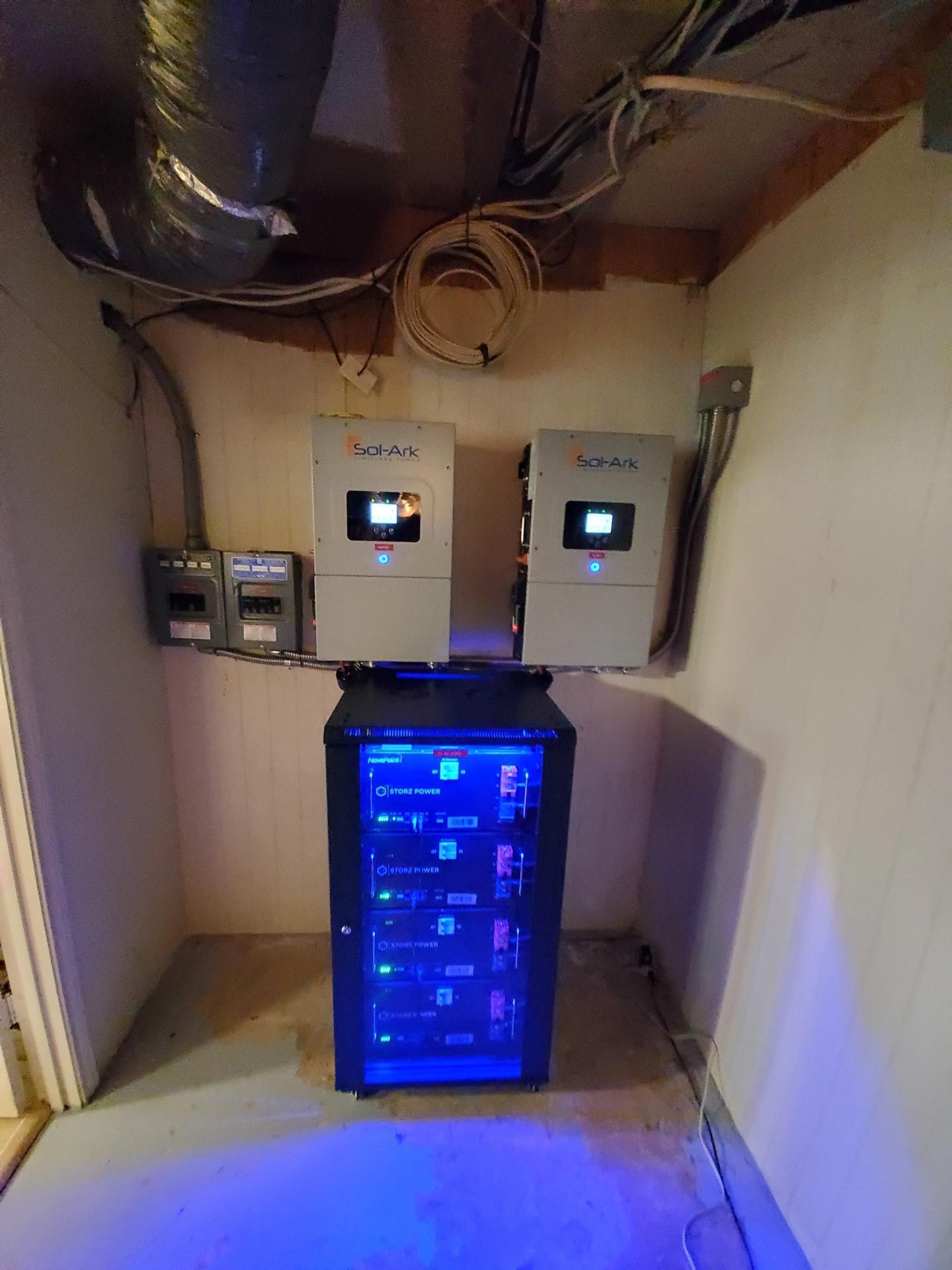 A room with a lot of electrical equipment and a blue light on the floor.