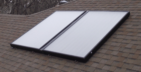 Two solar panels are sitting on top of a roof.