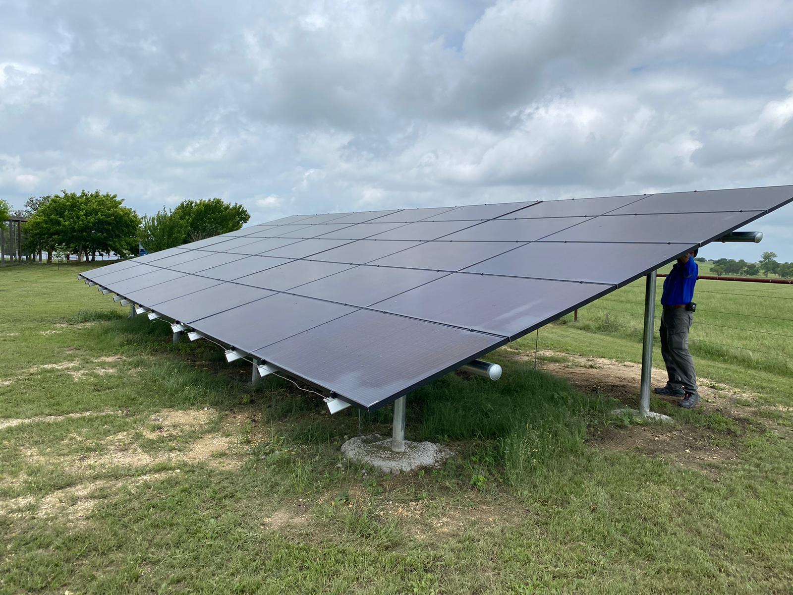A man is working on a solar panel in a field.
