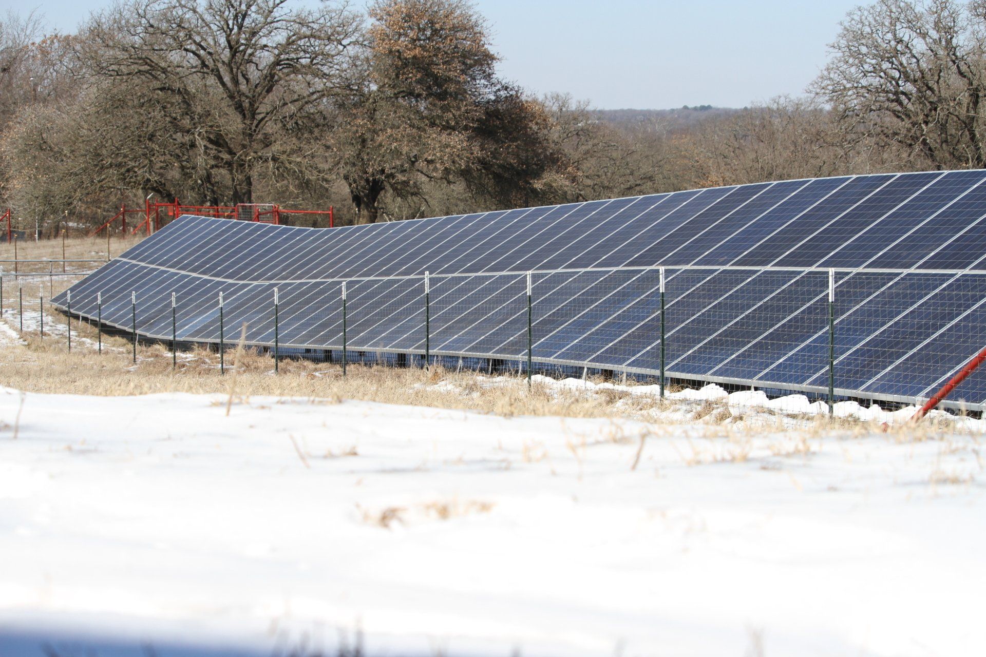 A row of solar panels in a snowy field