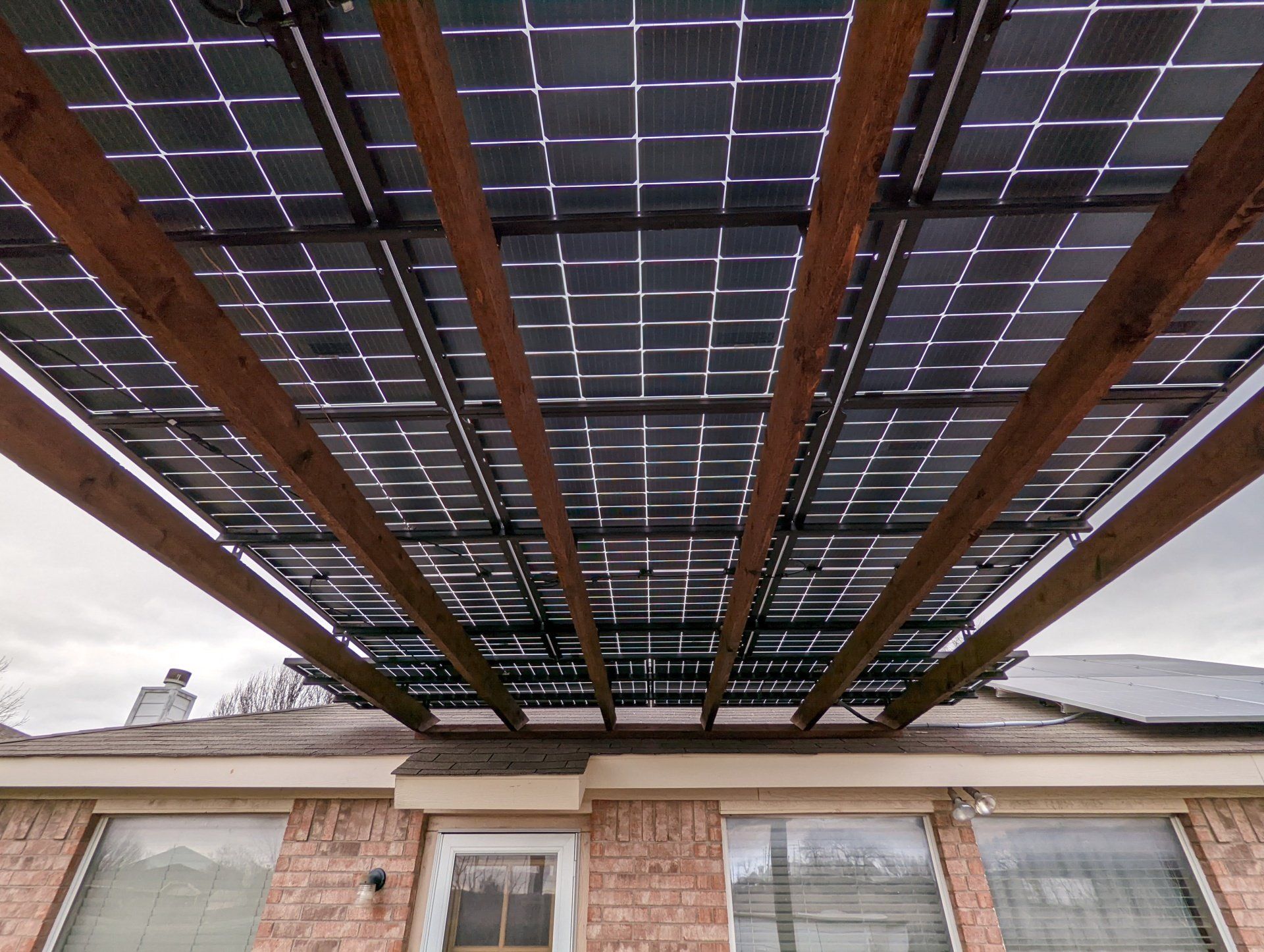 A house with a pergola and solar panels on the roof.