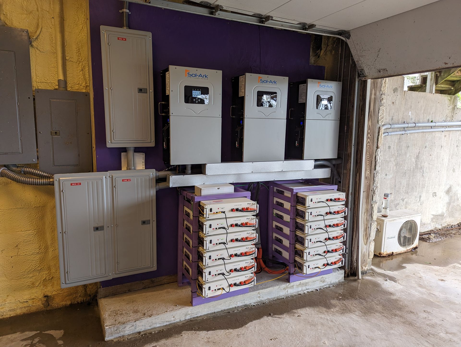 A room with a lot of electrical equipment and a purple wall.