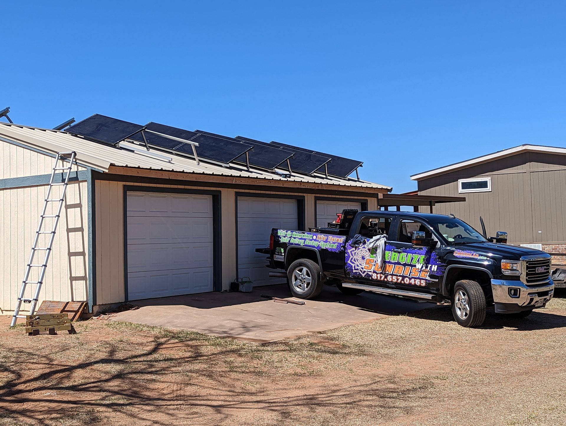 A truck is parked in front of a garage with solar panels on the roof.