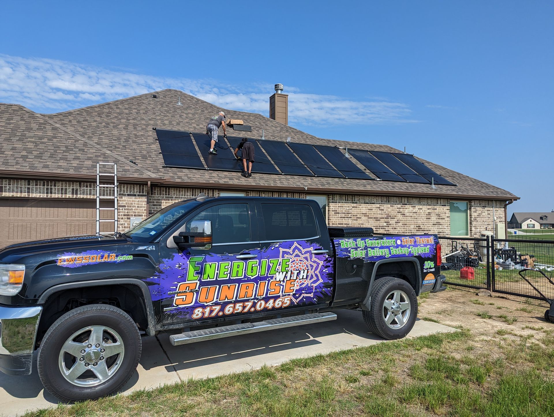 A truck is parked in front of a house with solar panels on the roof.