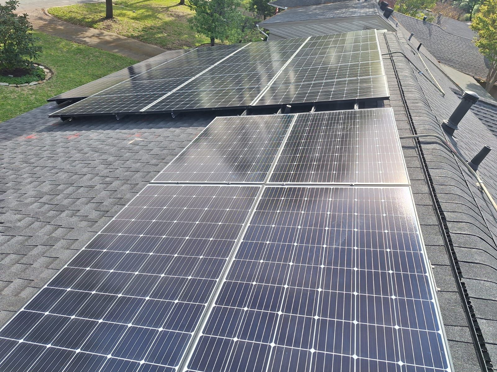 A row of solar panels are sitting on top of a roof.