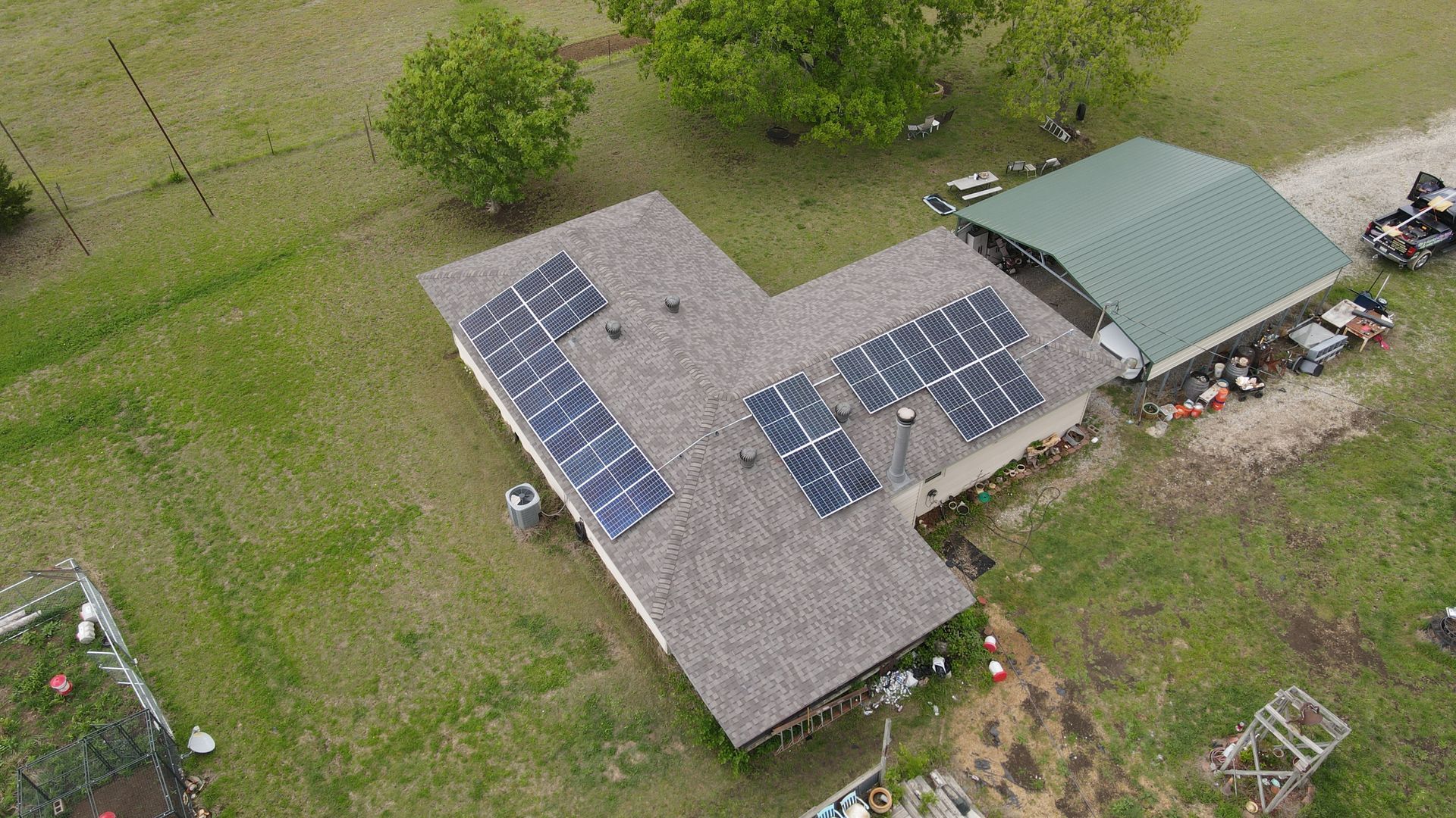 An aerial view of a house with solar panels on the roof.