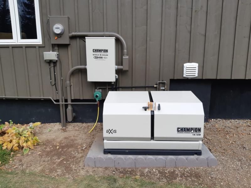 A camper generator is sitting outside of a house
