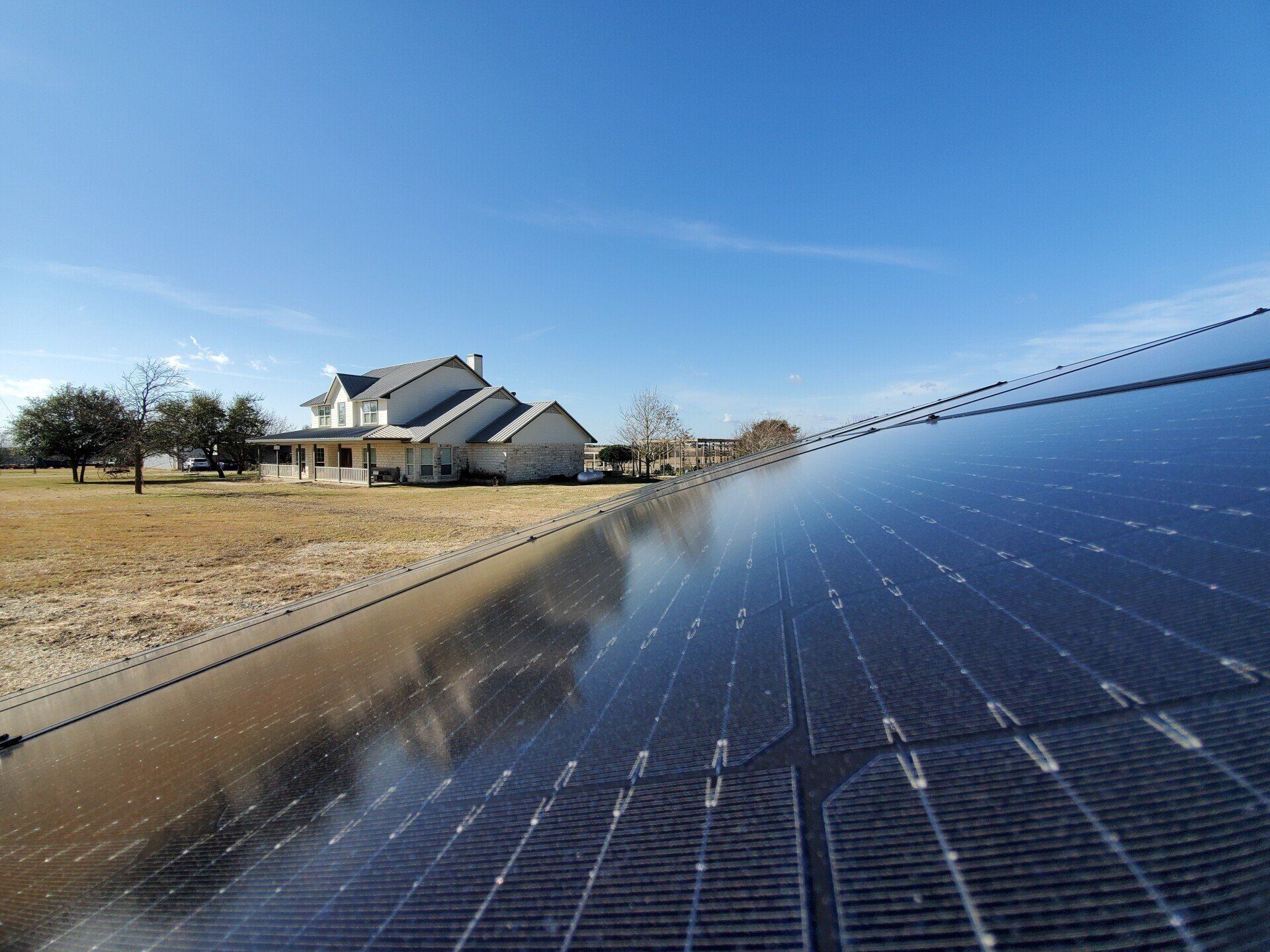 A solar panel is sitting in front of a house.