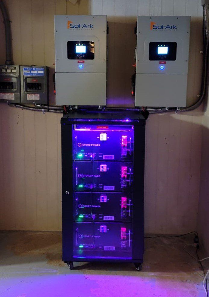 A purple light is shining on a rack of solar panels.