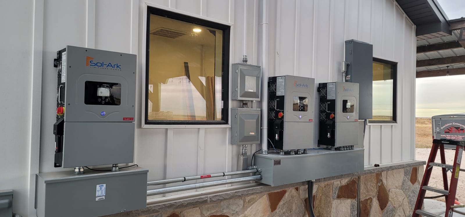 There are a lot of electrical boxes on the side of a building.