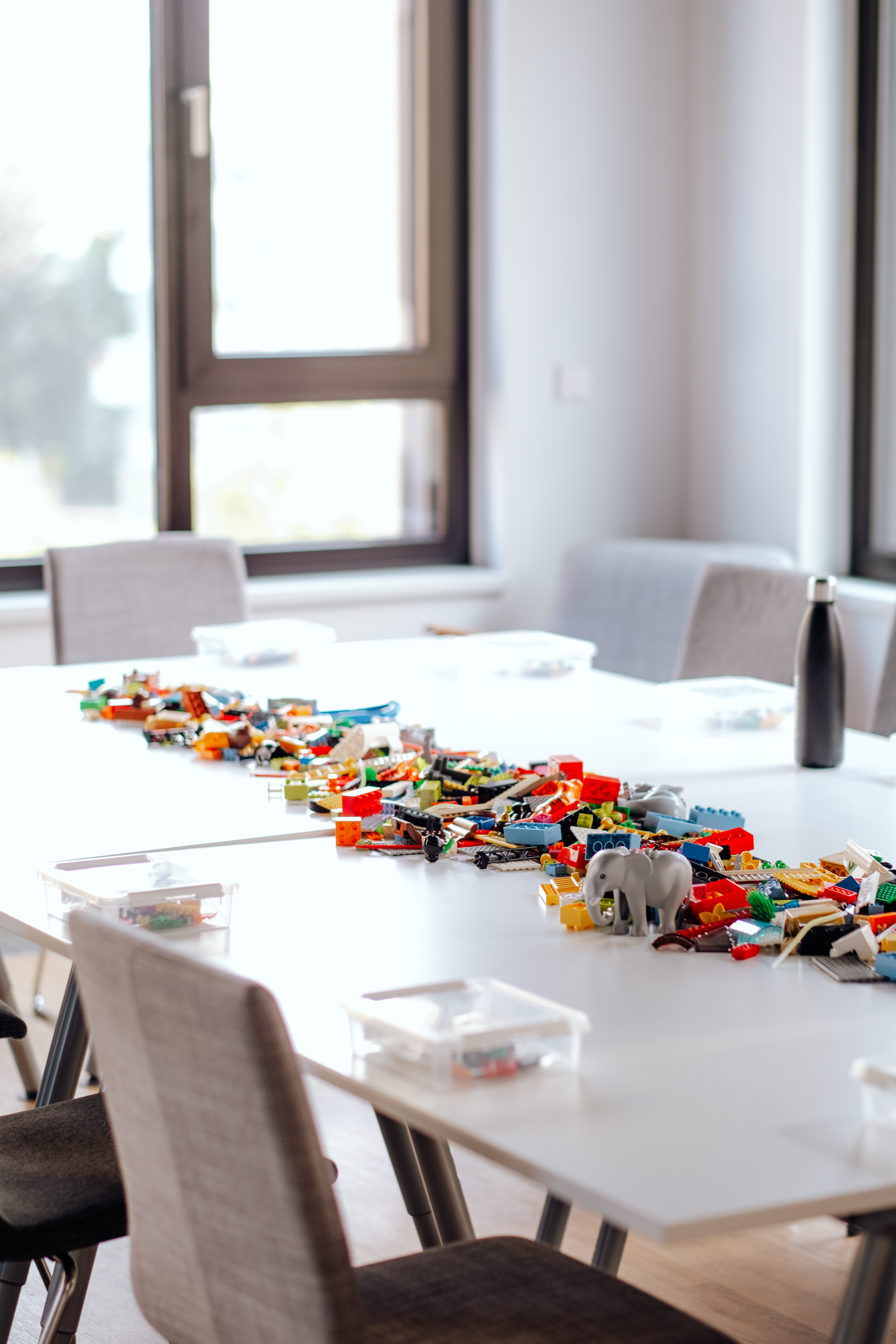 A table with a lot of lego bricks on it in a room.