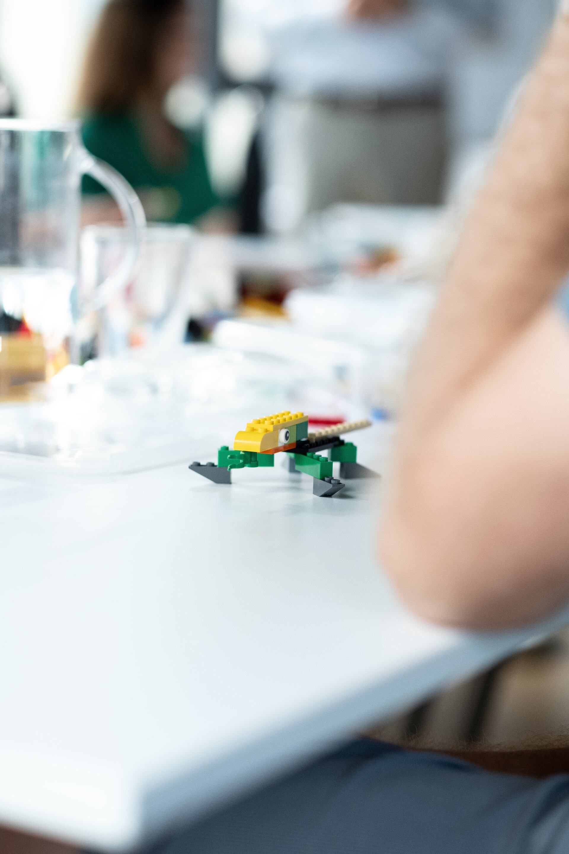 A person is sitting at a table with a toy on it.