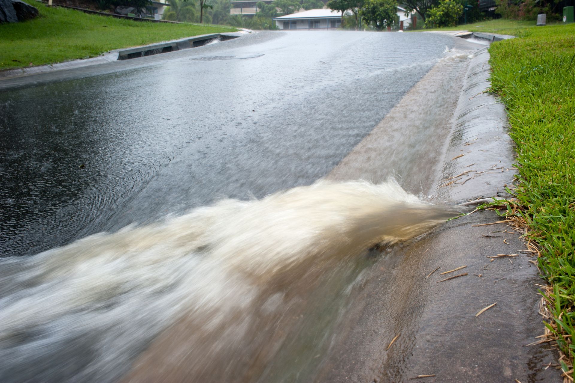 A flooded street with water running down the side of it.