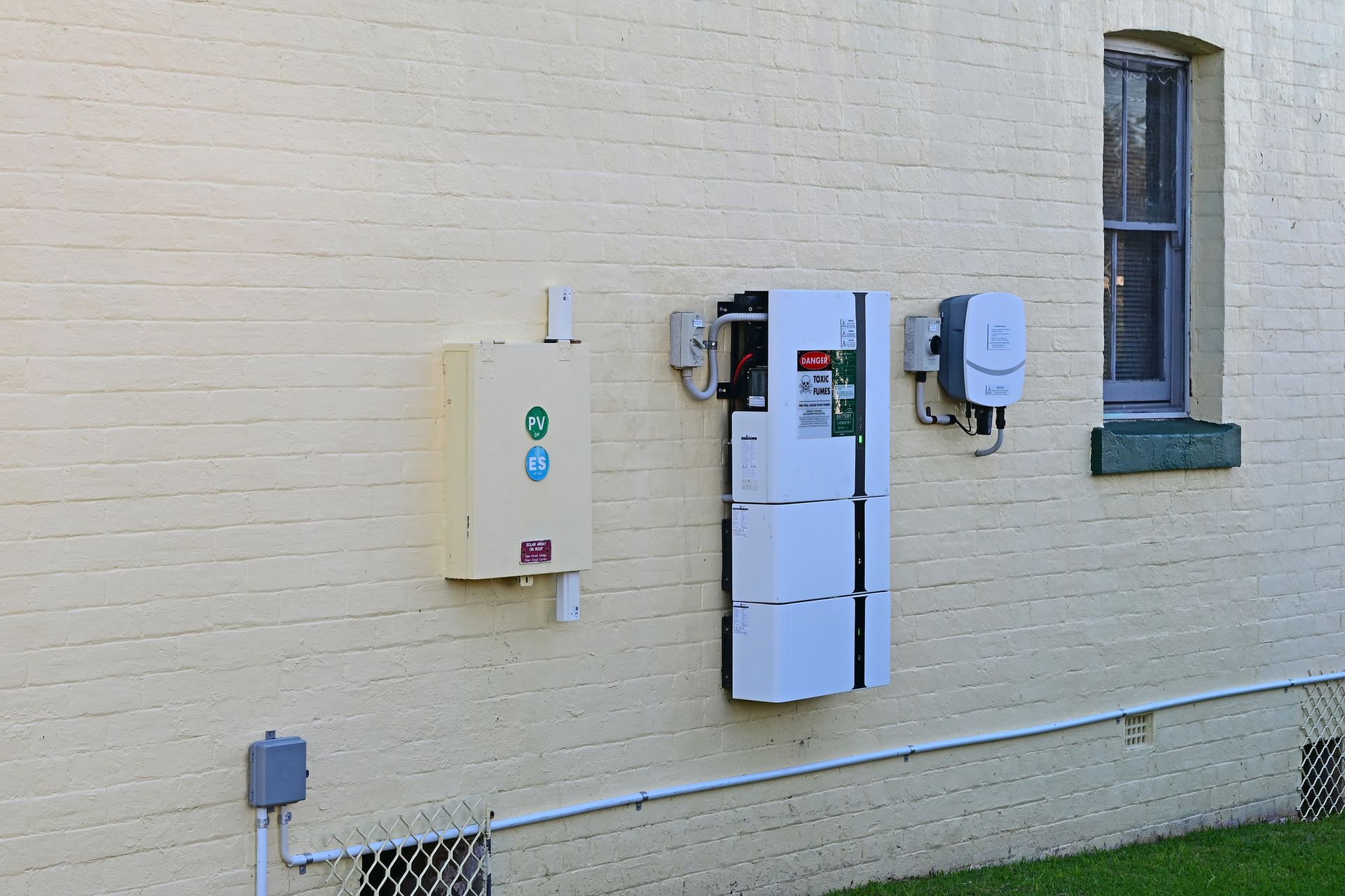 Solar home battery and inverter on a house wall.
