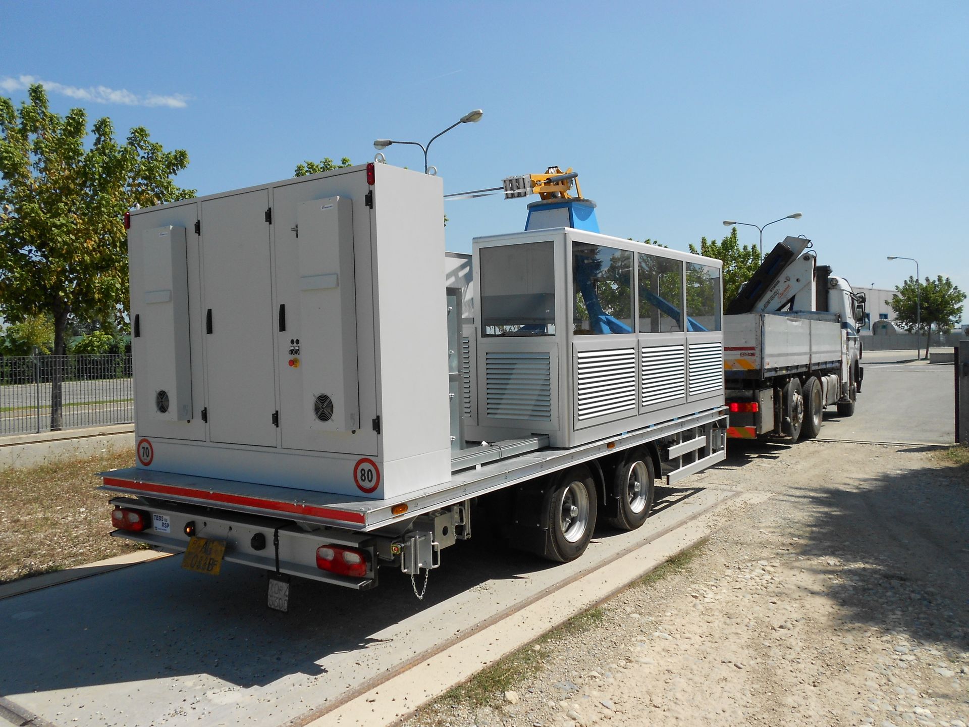 Camion che trasporta grandi attrezzature industriali in una giornata di sole.