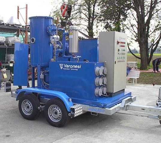 Unità industriale mobile blu su rimorchio, con pannello di controllo attaccato, in un ambiente esterno.