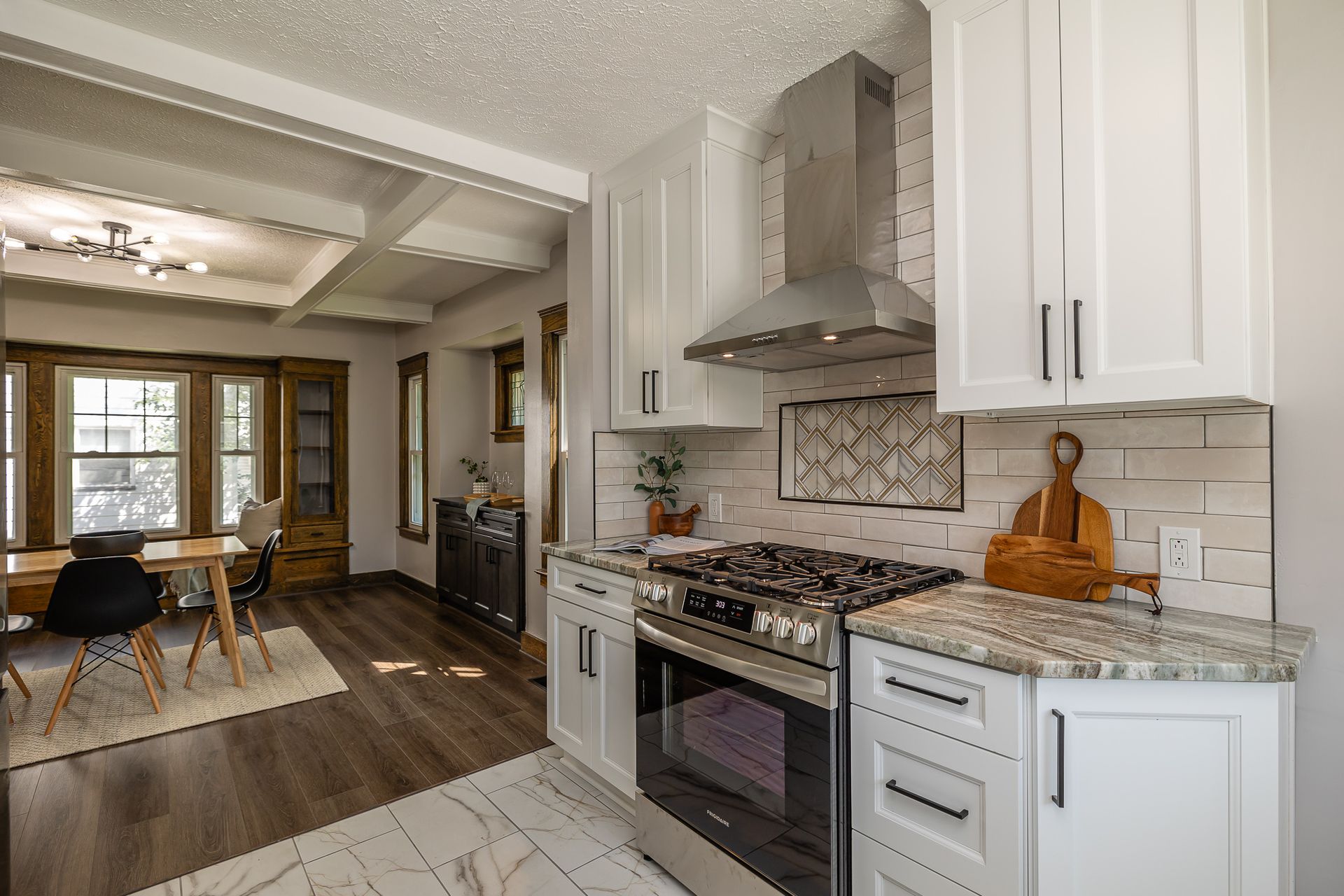 Kitchen with white cabinets, stainless steel appliances, and a dining area visible.