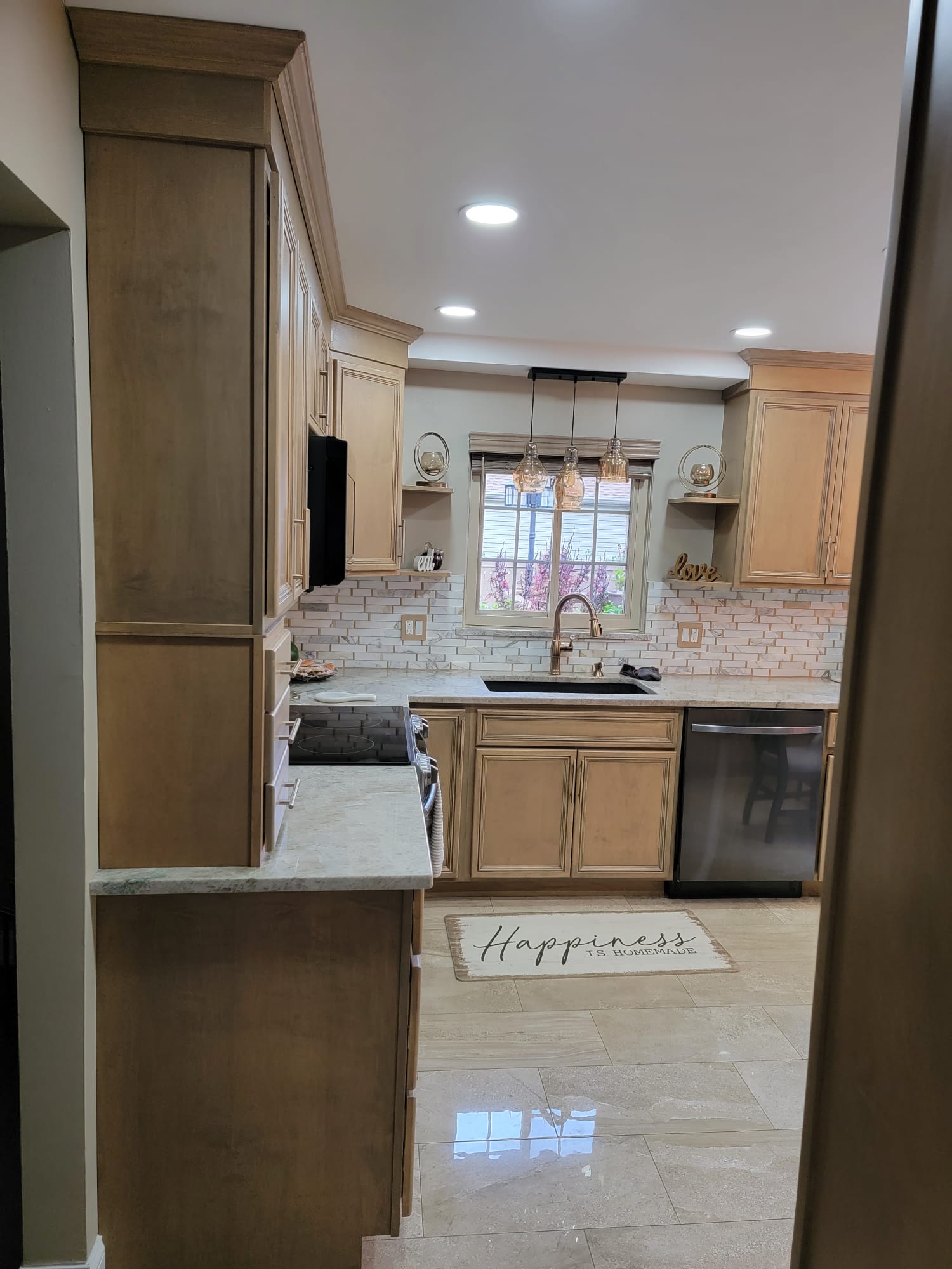 Kitchen with light wood cabinets, granite countertops, and stainless steel appliances.