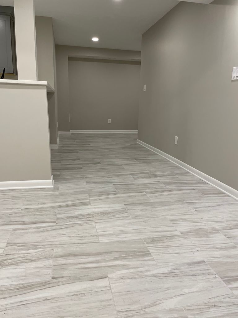 Empty interior room with gray tiled floor and beige walls.