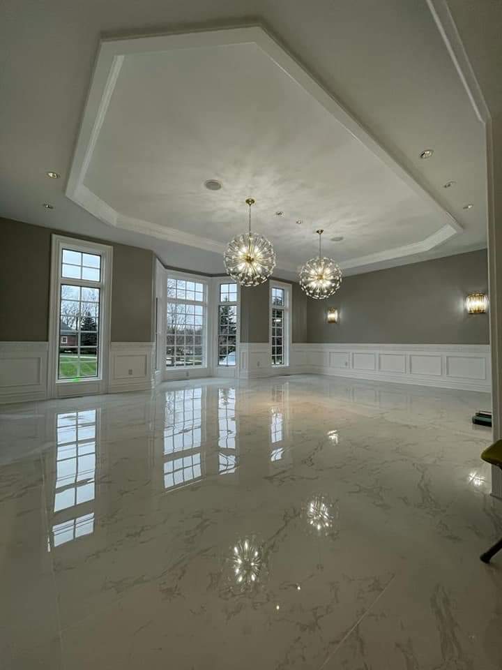 Spacious room with white marble floor, large windows, and decorative ceiling lights.