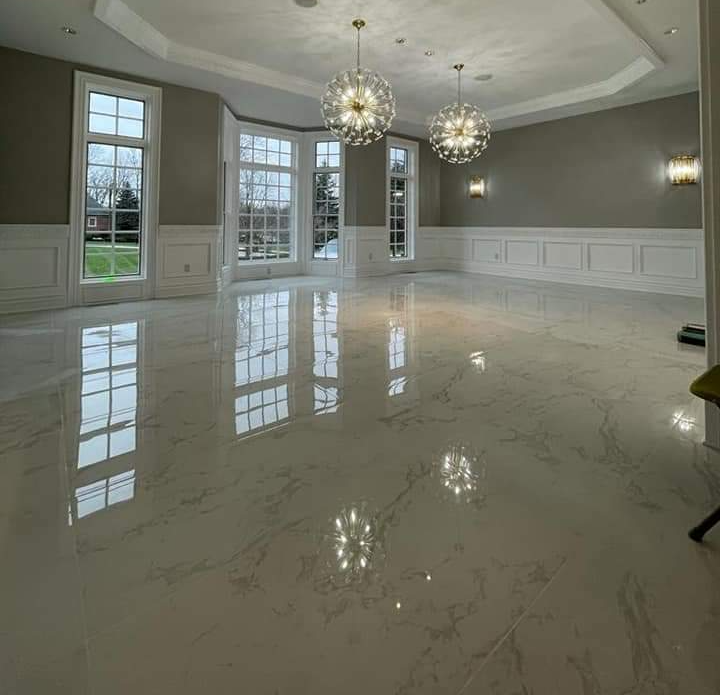 Empty, elegant room with glossy white marble floors, large windows, and crystal chandeliers.