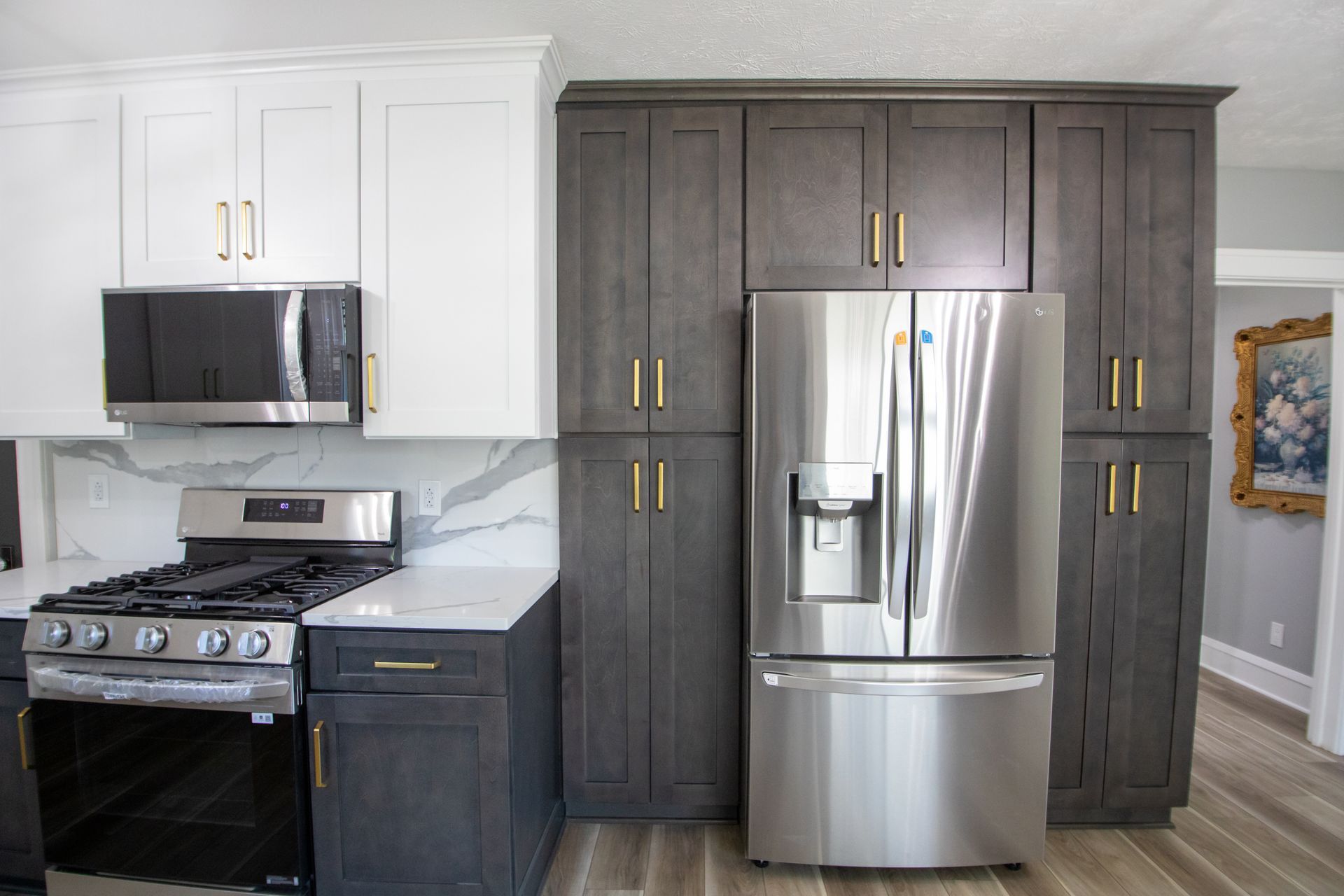 Kitchen with dark gray and white cabinets, stainless steel appliances, and a gas stove.