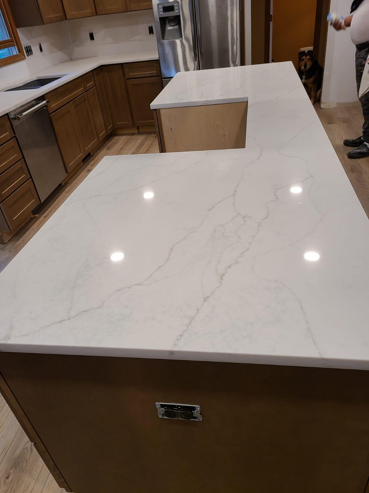White countertop with brown cabinets and appliances in kitchen.