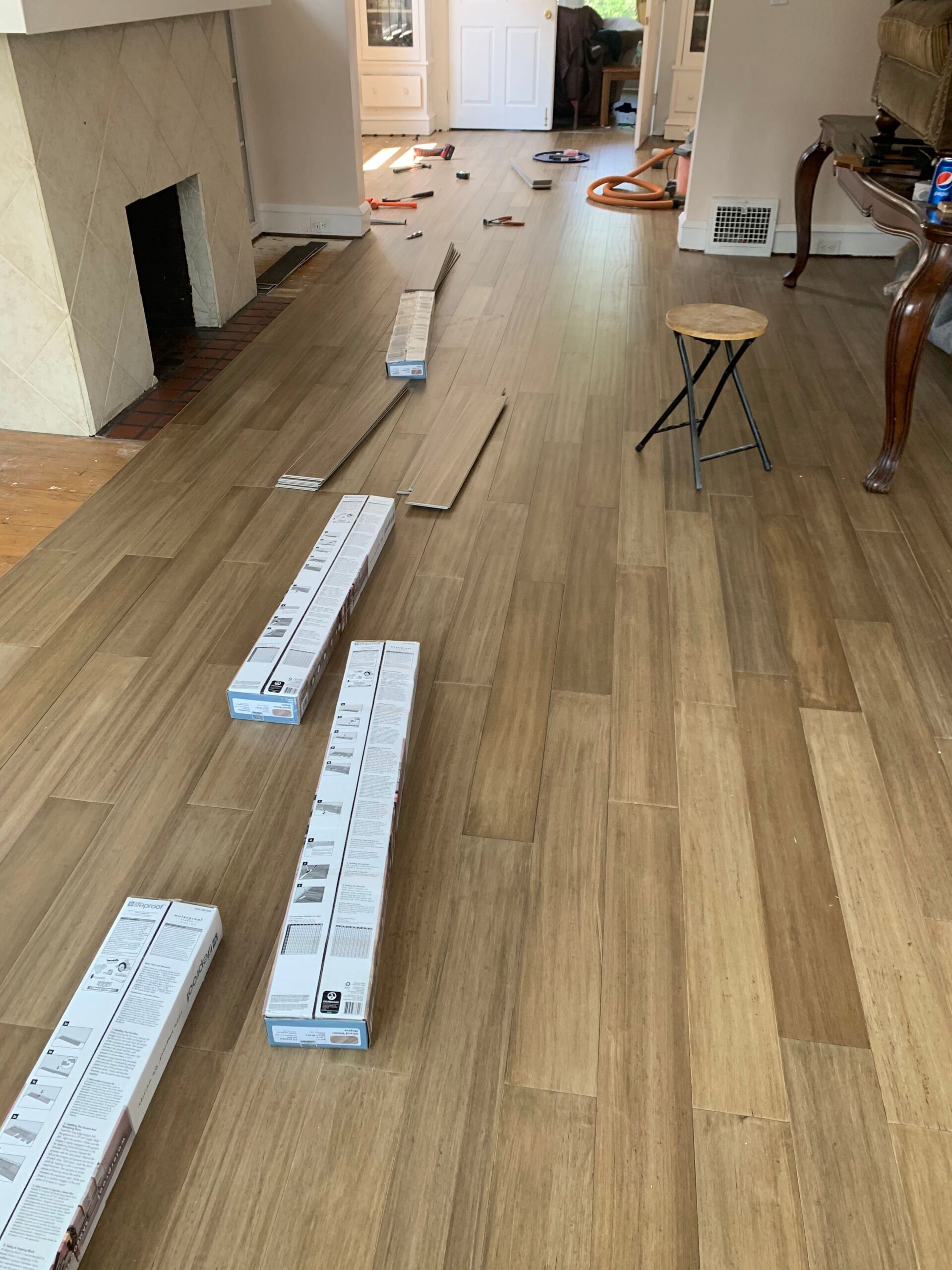 Laying wood flooring in a home, with boxes of planks in the process.