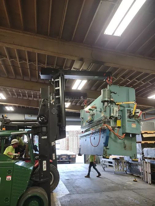 A Forklift is Lifting a Large Machine in a Factory | Wooster, OH | Bogner Construction Company