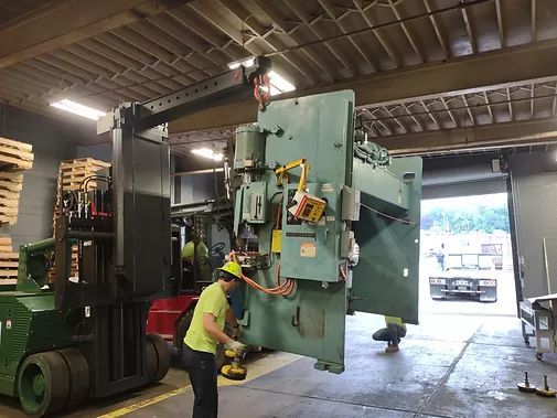 A Man is Lifting a Machine with a Forklift in a Warehouse | Wooster, OH | Bogner Construction Company