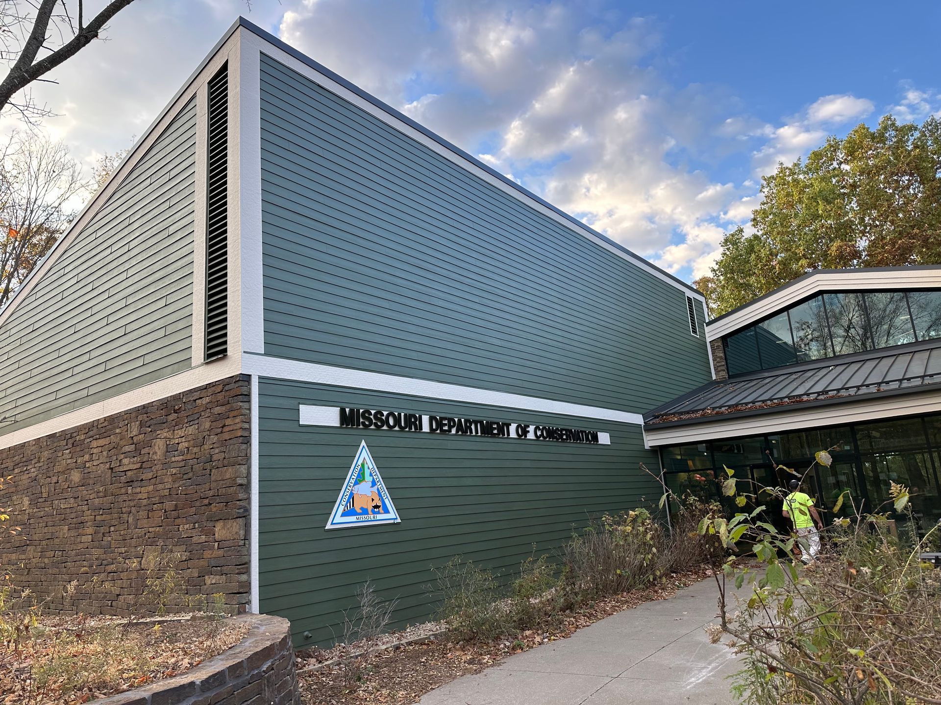 Missouri Department of Conservation building with teal siding, white trim, and a triangular logo.