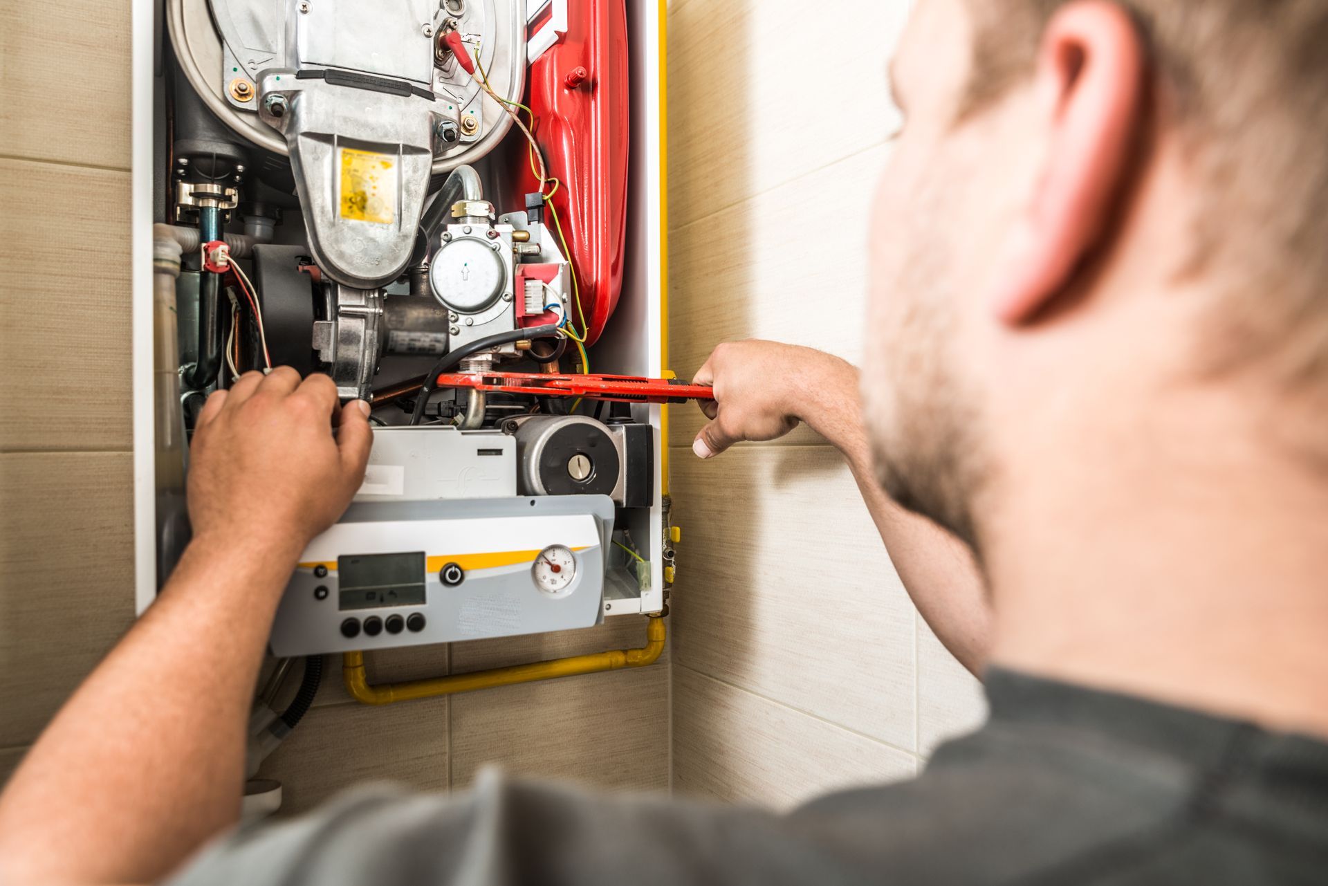HVAC technician inspecting heating system in North Royalton OH home during summer service visit.