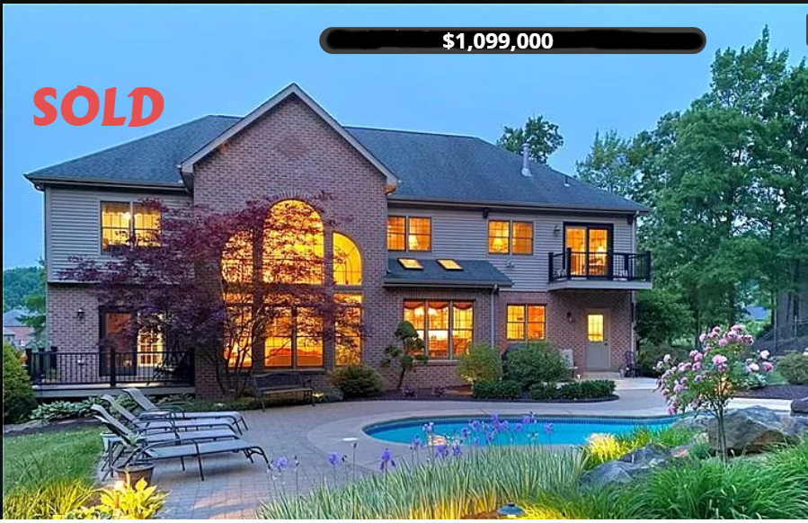 A two-story brick home with a pool. 