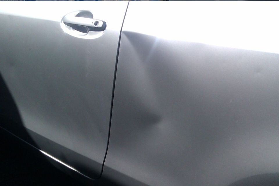 A Close Up of a Car With a Damaged Door — Dentmaster Refinishing In Bungalow, QLD