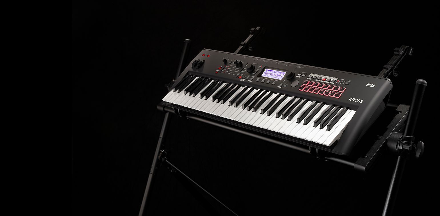 Keyboard synthesizer on a black stand against a black background.