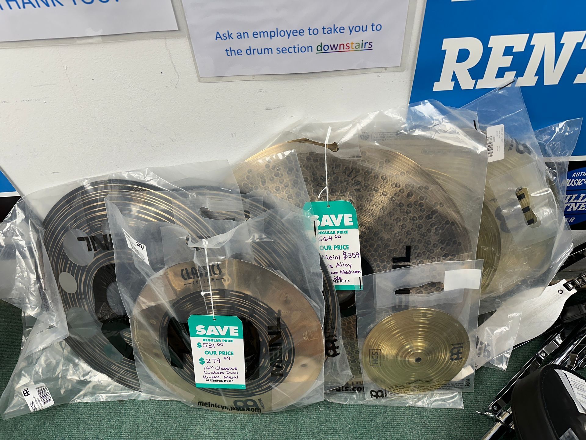 Cymbals in plastic bags with price tags, ready for sale.