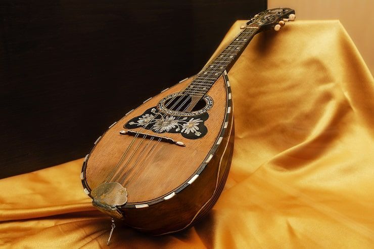 Ornate mandolin resting on golden fabric.