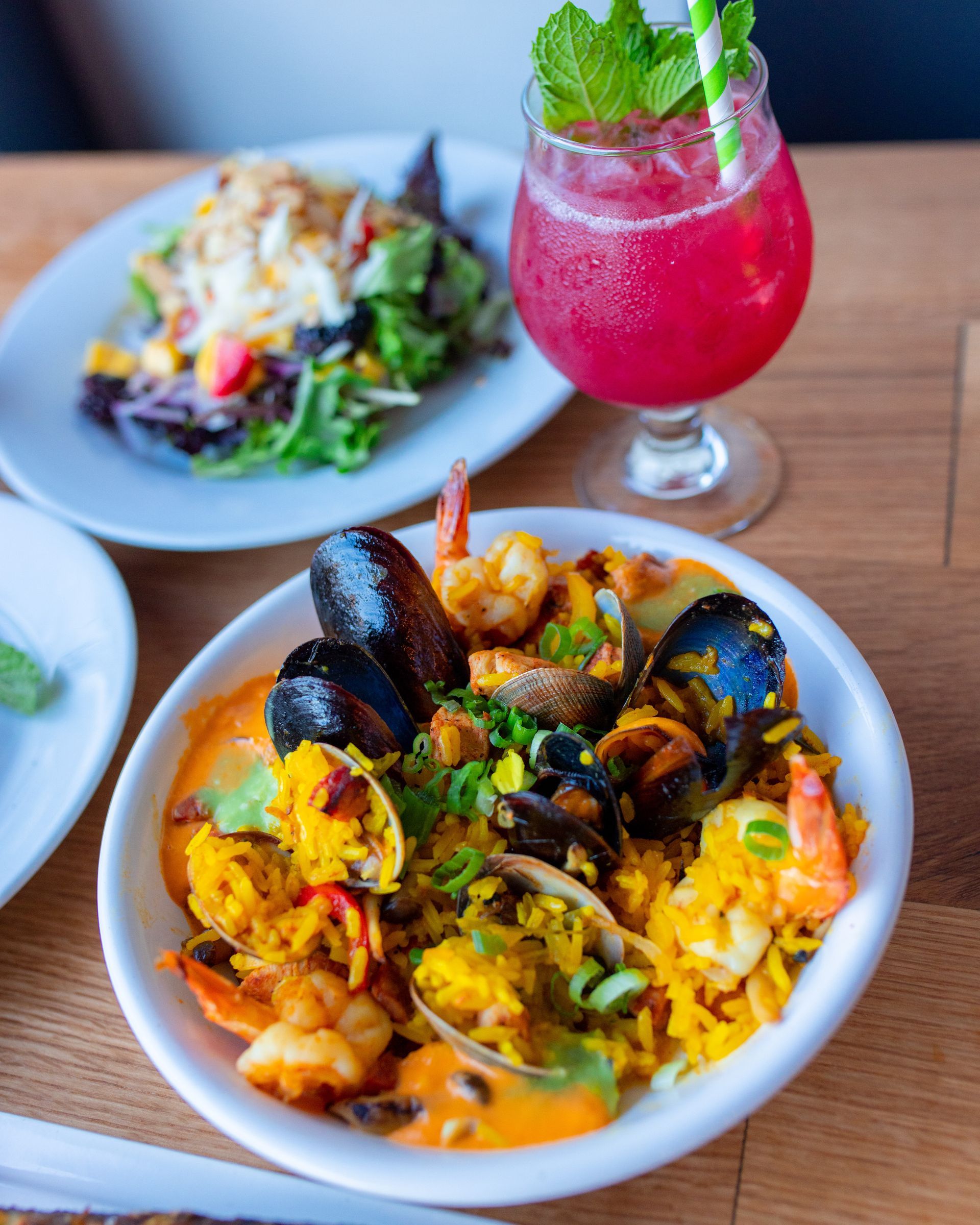 A bowl of food and a drink on a table.