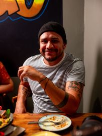 A man is sitting at a table with a plate of food.