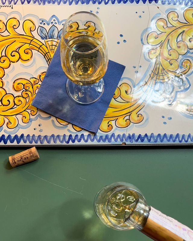 Una bottiglia di vino e un bicchiere di vino su un tavolo