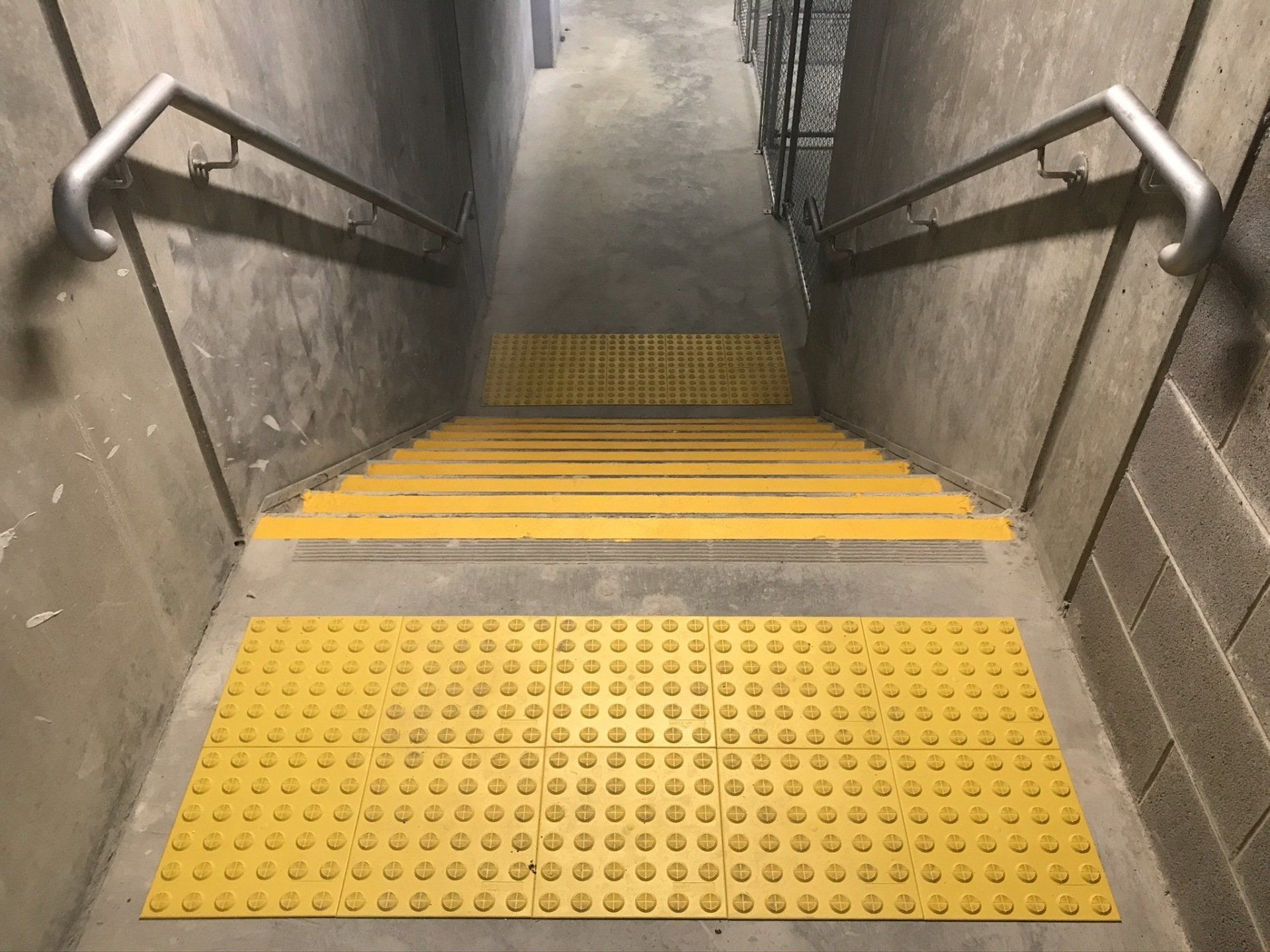 Set of stairs with galvanised handrails and yellow tactiles